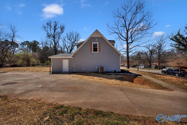 view of home's exterior with driveway and central air condition unit