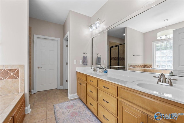 full bath with double vanity, tile patterned floors, a shower stall, and a sink
