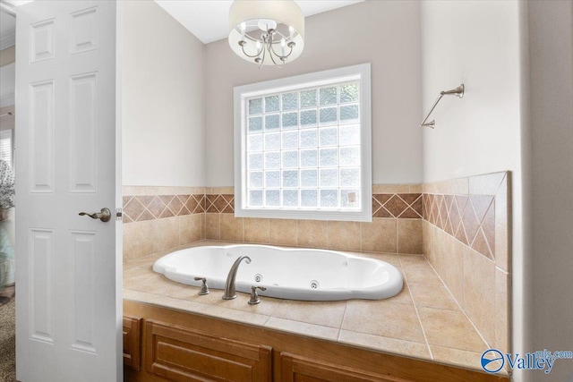 full bathroom featuring a tub with jets and a notable chandelier