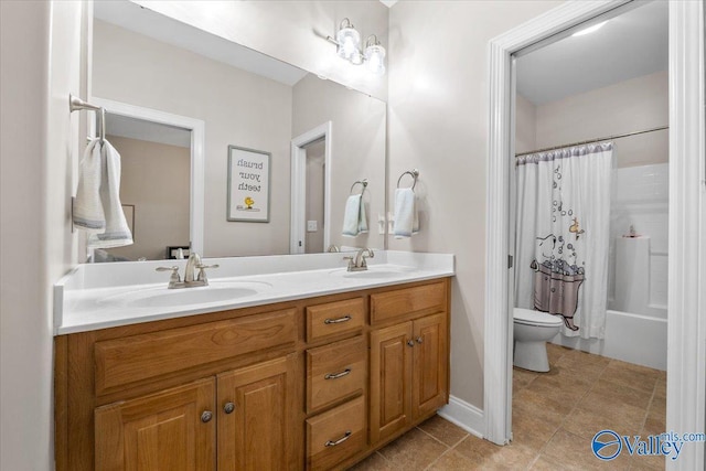 full bathroom featuring double vanity, a sink, tile patterned flooring, and toilet