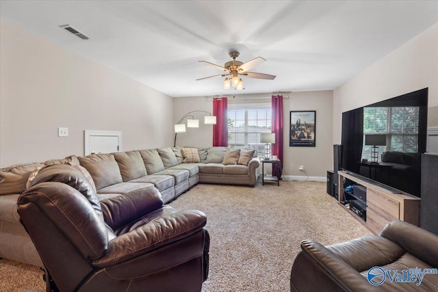 living area with baseboards, a ceiling fan, light colored carpet, and visible vents