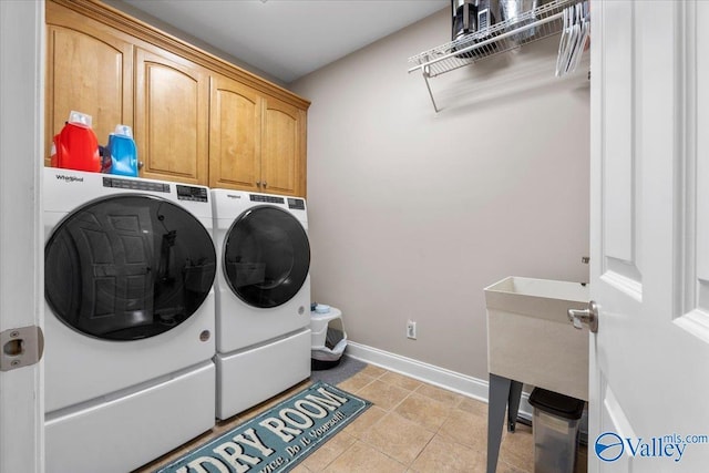 laundry room featuring baseboards, cabinet space, independent washer and dryer, and light tile patterned floors
