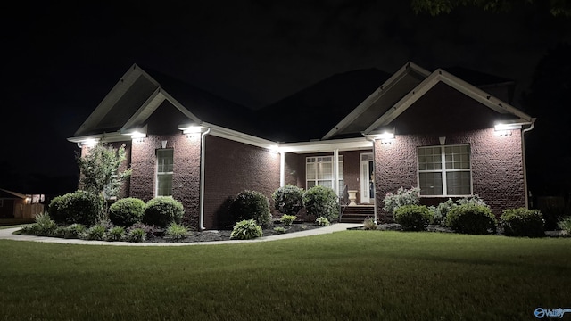 craftsman-style home with a lawn and brick siding