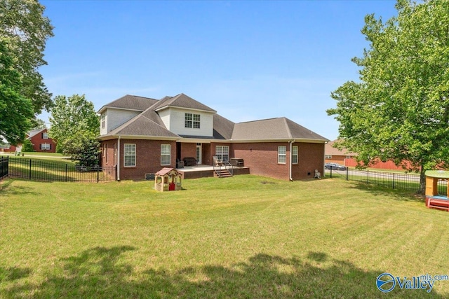rear view of house with a lawn, brick siding, and a fenced backyard