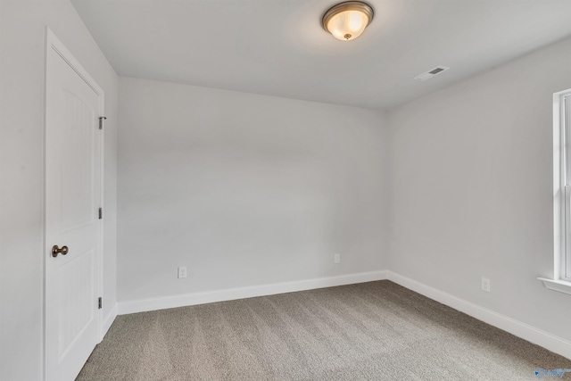 empty room featuring visible vents, baseboards, and carpet