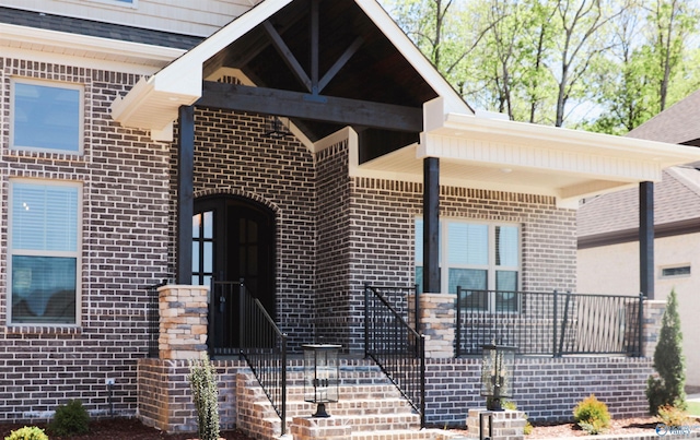 property entrance with brick siding and a shingled roof