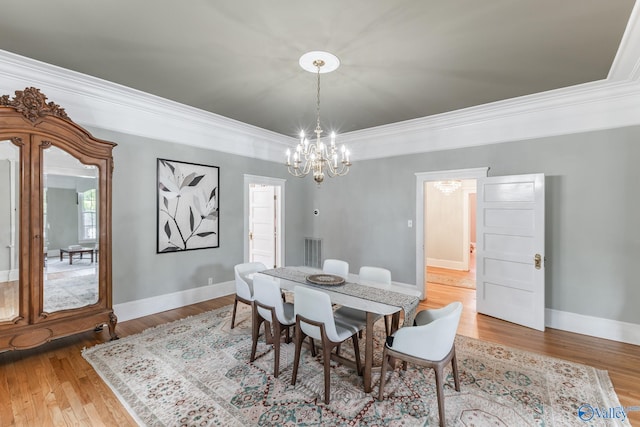 dining room featuring crown molding, a notable chandelier, and hardwood / wood-style floors