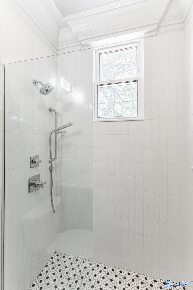 bathroom with a tile shower and crown molding