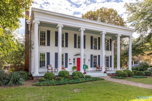 greek revival house with a porch and a front lawn