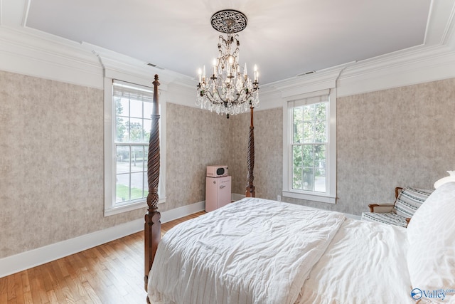 bedroom featuring multiple windows, a chandelier, and wood-type flooring