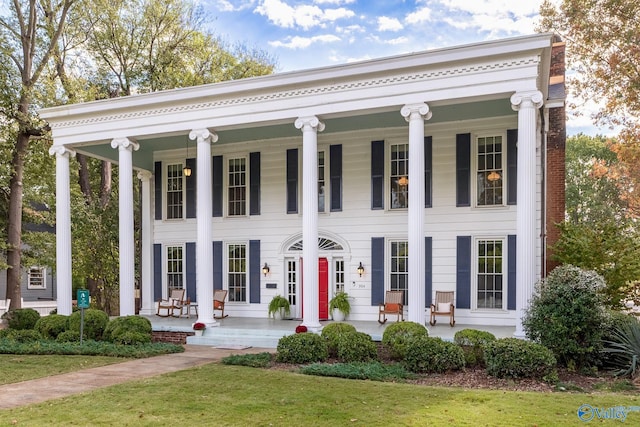 neoclassical / greek revival house with a front yard and a porch