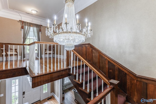 904 Line St NE, Decatur, AL 35601 - staircase with crown molding, wood finished floors, and a notable chandelier