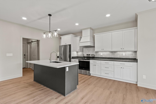 kitchen with pendant lighting, sink, appliances with stainless steel finishes, custom exhaust hood, and a barn door