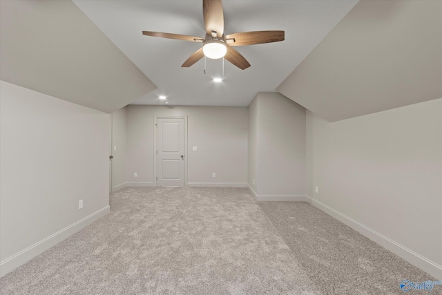 additional living space featuring vaulted ceiling, light colored carpet, and ceiling fan