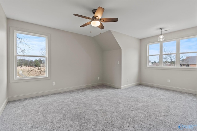 bonus room with plenty of natural light, light colored carpet, and ceiling fan