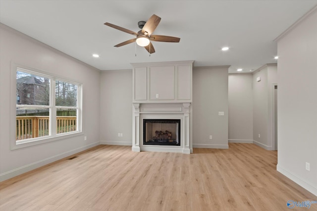 unfurnished living room with crown molding, ceiling fan, and light wood-type flooring