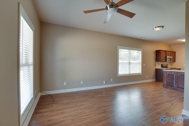 unfurnished living room with ceiling fan and hardwood / wood-style flooring