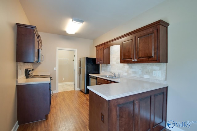 kitchen featuring light hardwood / wood-style floors, backsplash, sink, and stainless steel appliances