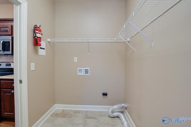 clothes washing area with hookup for an electric dryer, washer hookup, and light tile patterned floors