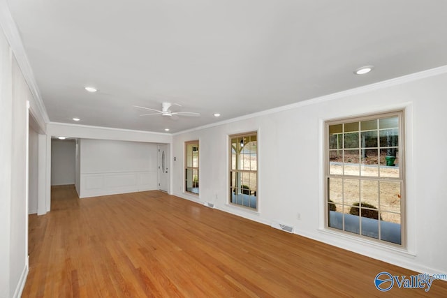 unfurnished living room featuring crown molding, ceiling fan, and light hardwood / wood-style floors