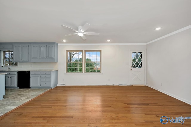 interior space with sink, ornamental molding, light hardwood / wood-style floors, and a healthy amount of sunlight