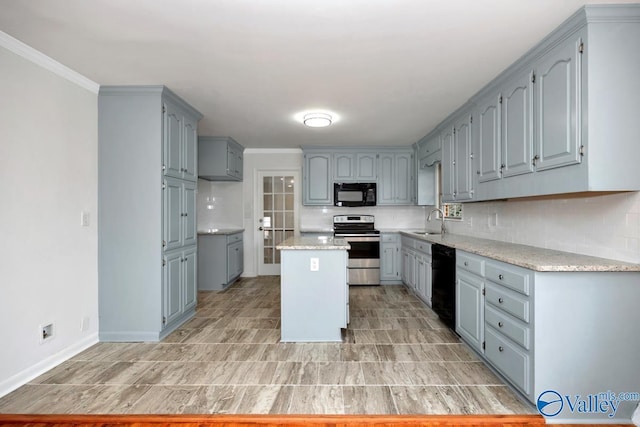 kitchen featuring sink, decorative backsplash, black appliances, and a kitchen island