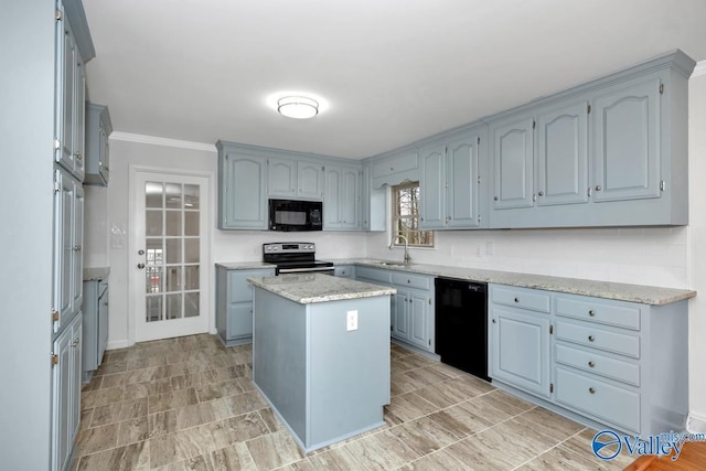 kitchen featuring sink, a center island, light stone counters, ornamental molding, and black appliances