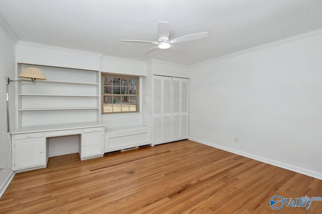 unfurnished bedroom featuring ornamental molding, built in desk, ceiling fan, and light hardwood / wood-style floors