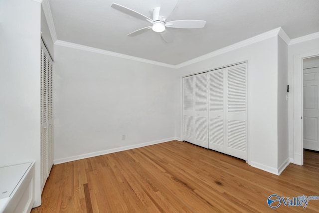 unfurnished bedroom with hardwood / wood-style flooring, ceiling fan, crown molding, and a closet