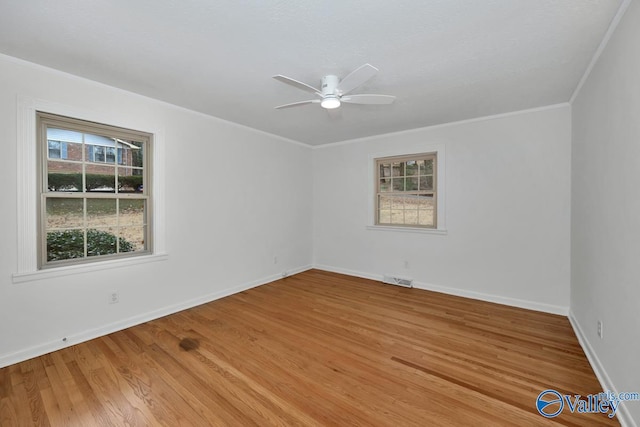 empty room with hardwood / wood-style floors, crown molding, and ceiling fan