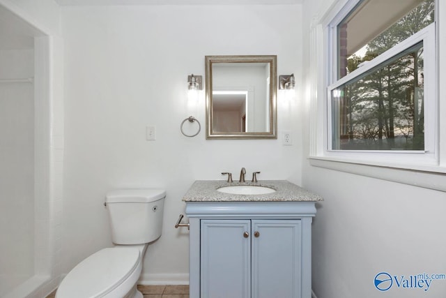 bathroom with tile patterned flooring, vanity, and toilet