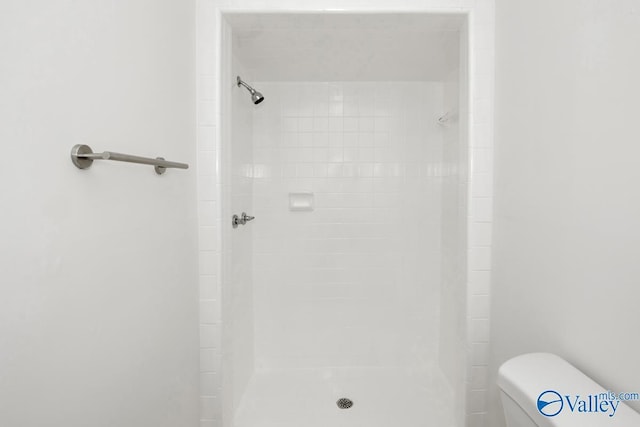 bathroom featuring toilet and tiled shower