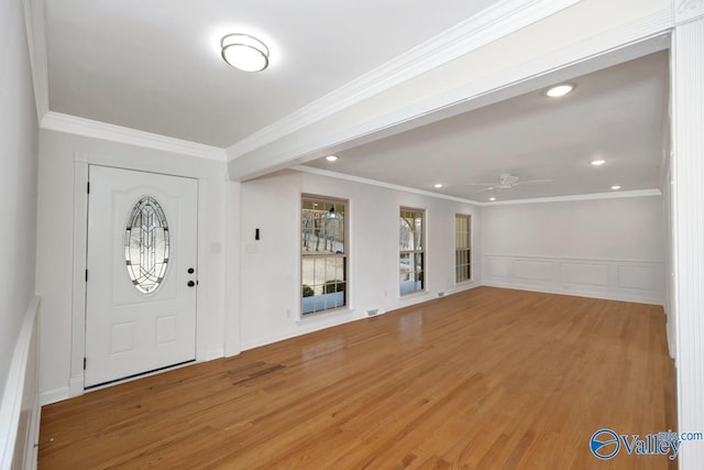 foyer entrance featuring crown molding, wood-type flooring, and ceiling fan