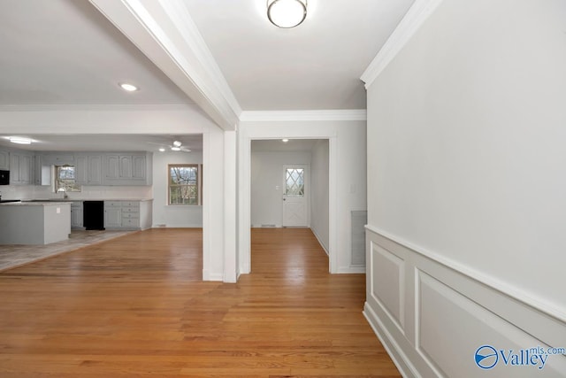 entryway with sink, crown molding, light hardwood / wood-style floors, and ceiling fan