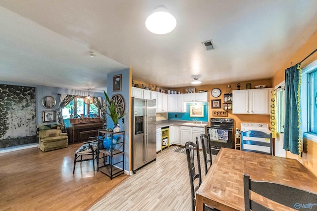 2122 Fernbrook Dr NE, Huntsville, AL 35811 - kitchen with range with electric stovetop, stainless steel fridge, white cabinets, light wood-style flooring, and range