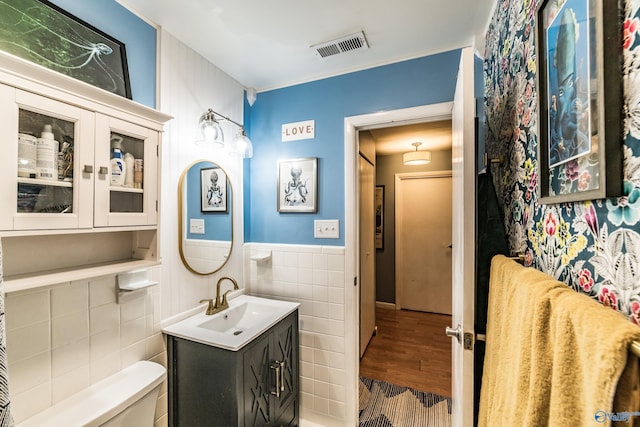 2122 Fernbrook Dr NE, Huntsville, AL 35811 - bathroom featuring tile walls, toilet, vanity, wood finished floors, and wainscoting