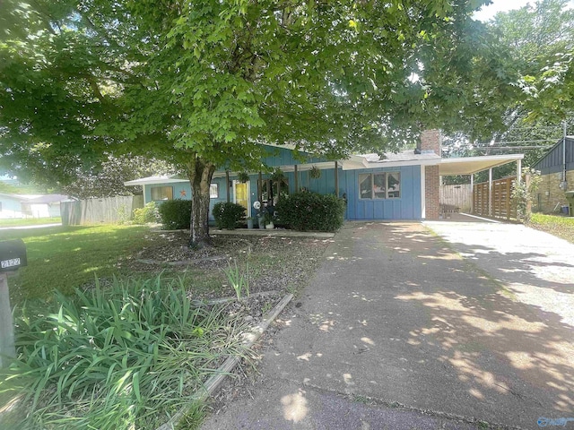 2122 Fernbrook Dr NE, Huntsville, AL 35811 - view of property hidden behind natural elements featuring a chimney, driveway, fence, and board and batten siding