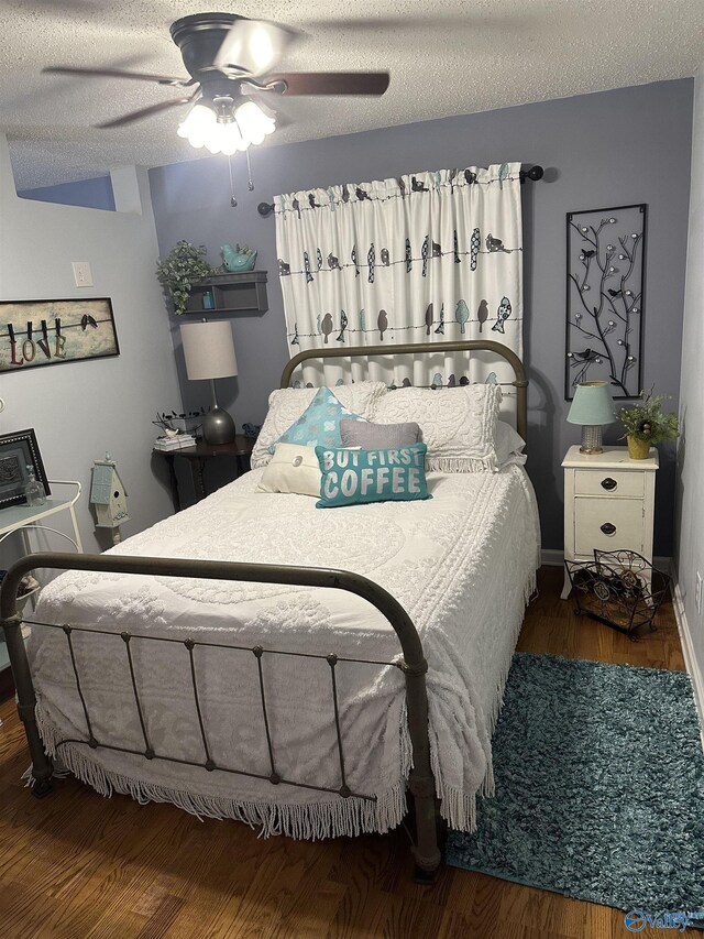 bedroom featuring a sink, wood finished floors, a textured ceiling, and freestanding refrigerator