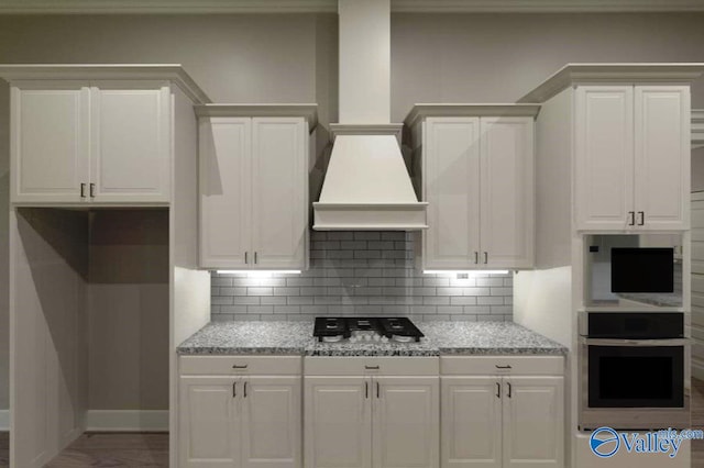 kitchen featuring appliances with stainless steel finishes, white cabinets, and tasteful backsplash