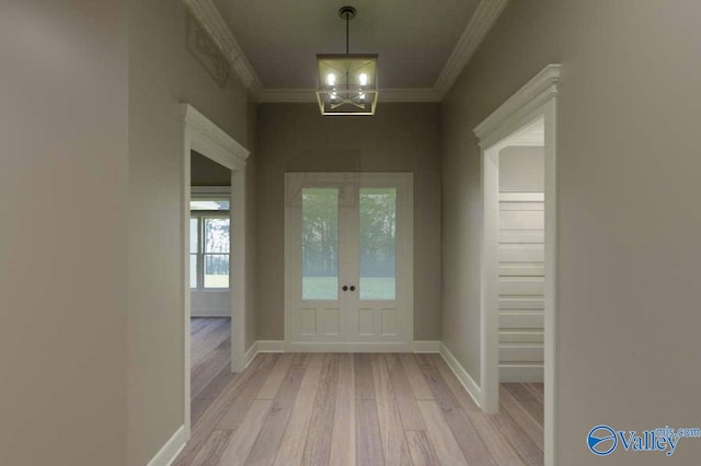 foyer with a chandelier, ornamental molding, baseboards, and light wood-style floors