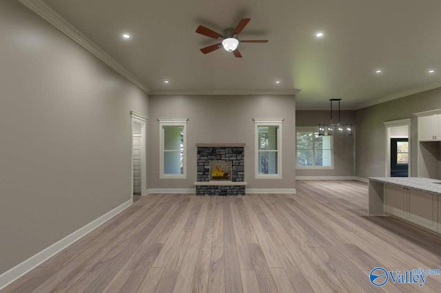 unfurnished living room featuring baseboards, ceiling fan, ornamental molding, light wood-type flooring, and a fireplace