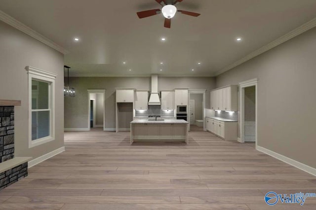 kitchen featuring ornamental molding, white cabinetry, light wood-style flooring, and decorative backsplash