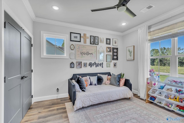 bedroom with ornamental molding, ceiling fan, a closet, and wood-type flooring