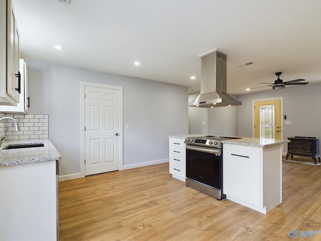 kitchen with white cabinetry, sink, stainless steel electric range oven, light hardwood / wood-style flooring, and island exhaust hood