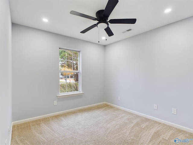 spare room with light colored carpet and ceiling fan