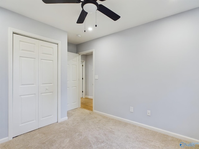 unfurnished bedroom featuring light colored carpet, ceiling fan, and a closet