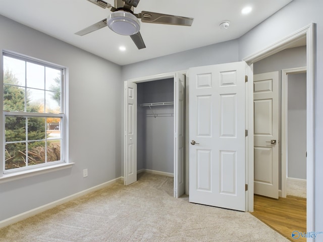 unfurnished bedroom featuring a closet, light colored carpet, and ceiling fan