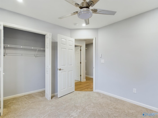 unfurnished bedroom featuring ceiling fan, a closet, and light colored carpet