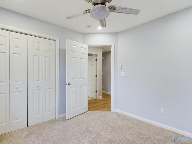 unfurnished bedroom featuring light carpet, ceiling fan, and a closet