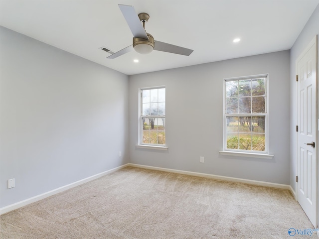 carpeted empty room featuring a wealth of natural light and ceiling fan